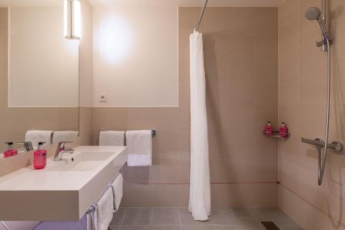 阿姆斯特丹Moxy Amsterdam Houthavens的浴室配有白色水槽和淋浴。