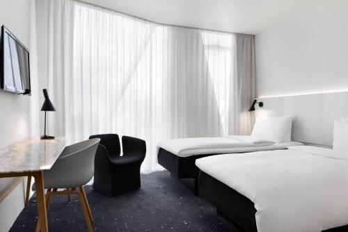 哥本哈根哥本哈根贝拉天空万豪AC酒店的酒店客房,配有两张床和椅子