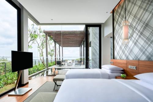 乌鲁瓦图巴厘岛乌鲁瓦图万丽度假酒店及Spa的一间卧室配有两张床和一台平面电视