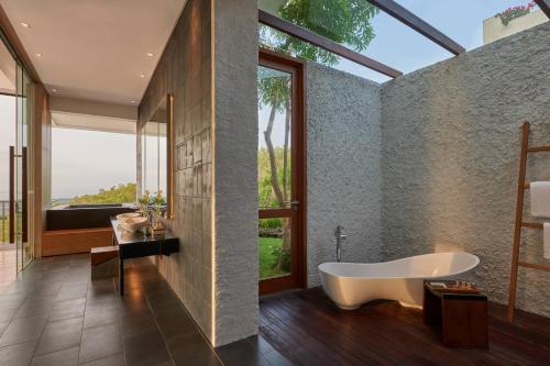 乌鲁瓦图巴厘岛乌鲁瓦图万丽度假酒店及Spa的带浴缸的浴室和大窗户