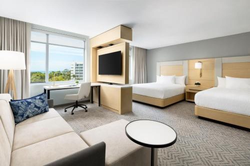 圣胡安Residence Inn by Marriott San Juan Isla Verde的酒店客房,设有两张床和一张沙发