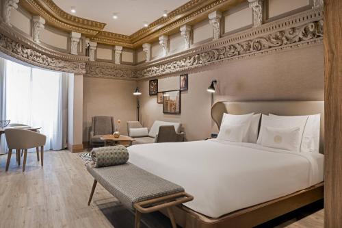 马德里圈大街傲途格精选酒店（仅限成人入住）的一间带大床的卧室和一间客厅
