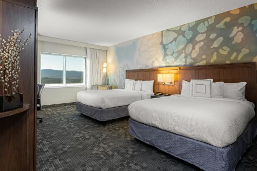 Arden阿什维尔机场万怡酒店的酒店客房设有两张床,墙上挂有绘画作品