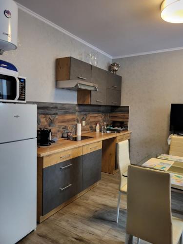 尤尔马拉Guest house Sunny的厨房配有木制橱柜和白色冰箱。