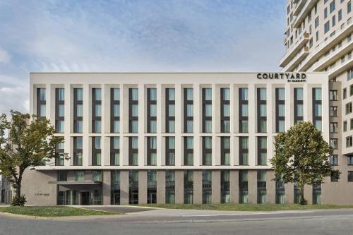 汉堡Courtyard by Marriott Hamburg City的一座白色的大建筑,上面有标志