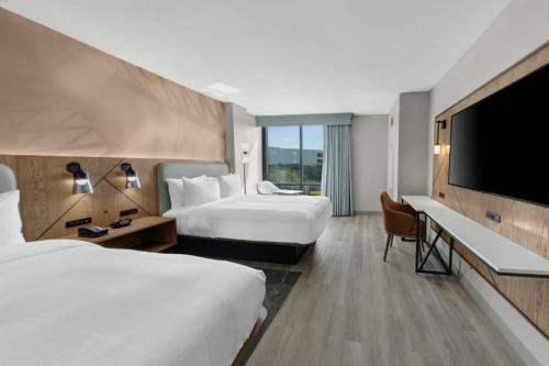 休斯顿北休斯敦万豪酒店的酒店客房设有两张床和一台平面电视。