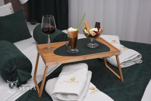 斯雷姆斯卡米特罗维察VESTA Apartman的一张桌子,上面放着两杯葡萄酒和一碗食物