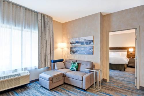 布兰奇堡帕克TownePlace Suites by Marriott Bridgewater Branchburg的酒店客房配有床、沙发和椅子