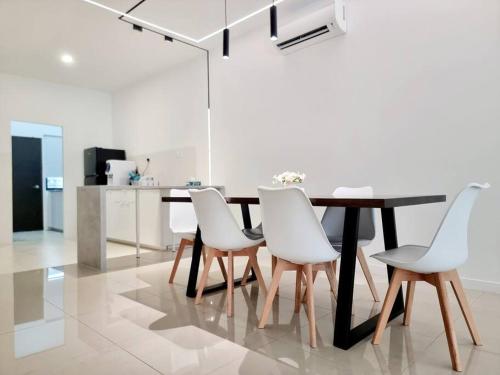 莎阿南H+M Residence [5min]to Setia City Convention的一间带桌子和白色椅子的用餐室
