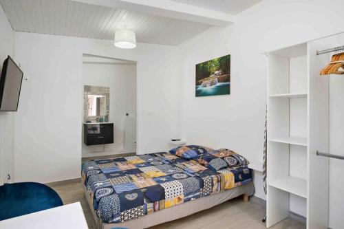 勒拉芒坦Le Camélia - Gîte "Terre et Truffes"的一间卧室设有一张床和白色的墙壁