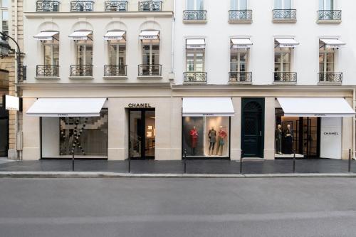 巴黎Chic Apartment on the famous shopping Rue du Faubourg Saint-Honoré street的白色遮阳篷建筑前的商店