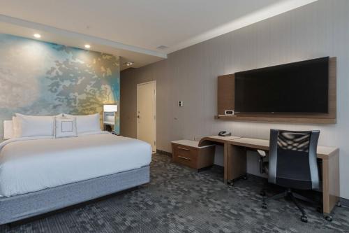 南本德Courtyard by Marriott South Bend Downtown的酒店客房设有一张床、一张书桌和一台电视机。