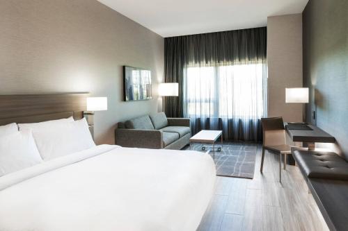 剑桥AC万豪波士顿剑桥酒店的酒店客房设有一张白色大床和一张沙发。