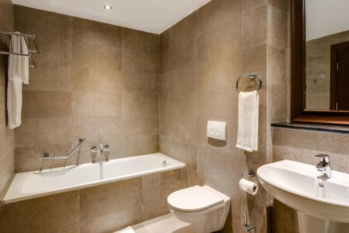 奥韦里Protea Hotel by Marriott Owerri Select的带浴缸、卫生间和盥洗盆的浴室