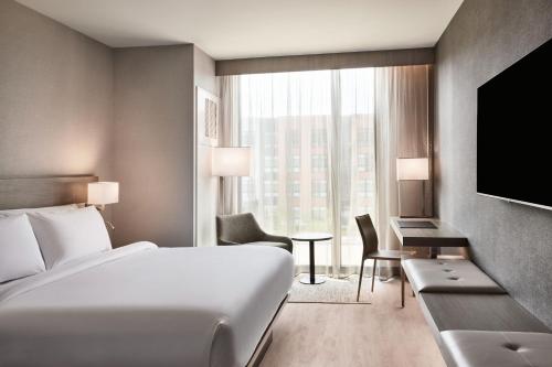 切斯特菲尔德AC Hotel by Marriott St Louis Chesterfield的酒店客房设有一张床和一个大窗户
