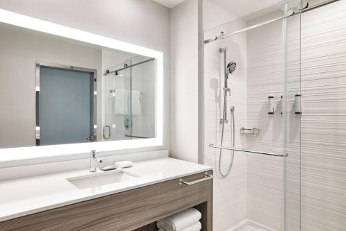 切斯特菲尔德AC Hotel by Marriott St Louis Chesterfield的白色的浴室设有水槽和淋浴。