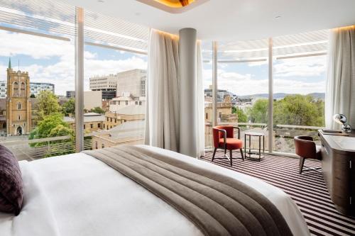 霍巴特The Tasman, a Luxury Collection Hotel, Hobart的酒店客房设有一张床和一个大窗户