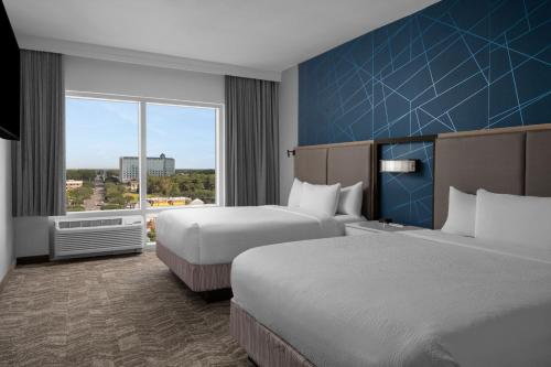 默特尔比奇SpringHill Suites by Marriott Myrtle Beach Oceanfront的酒店客房设有两张床和大窗户。