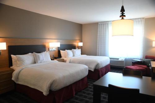 堪萨斯城TownePlace Suites Kansas City At Briarcliff的酒店客房设有两张床和窗户。