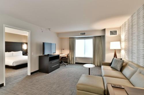 欧克莱尔Residence Inn by Marriott Eau Claire的酒店客房设有一张沙发和一张床