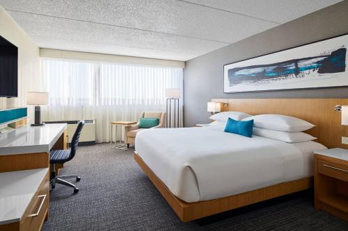 马斯基根Delta Hotels by Marriott Muskegon Convention Center的酒店客房设有一张大床和一张书桌。