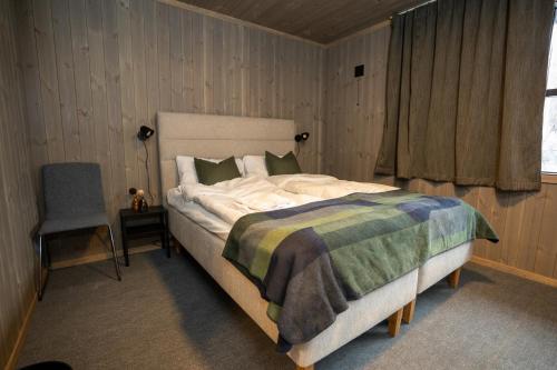 LjørdalFulufjellet的卧室配有床、椅子和窗户。