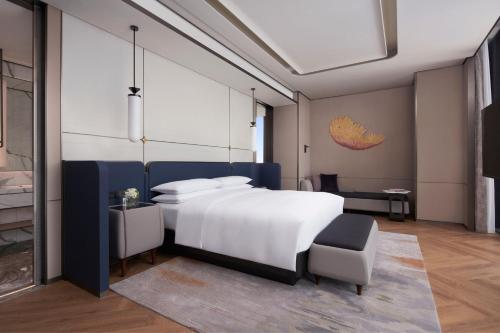 天津国家会展中心天津万豪酒店的卧室配有一张白色大床和一把椅子