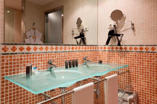 巴利亚多利德圣安娜帕拉西奥生活方式万豪AC酒店的浴室设有2个水槽和镜子