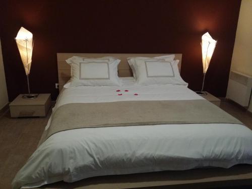 芒通Les Citronniers d'Azur的一间卧室配有一张带两盏灯的大型白色床。