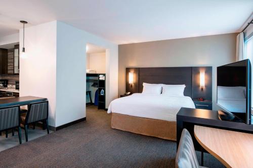 温尼伯Residence Inn by Marriott Winnipeg的酒店客房带一张床和一个厨房