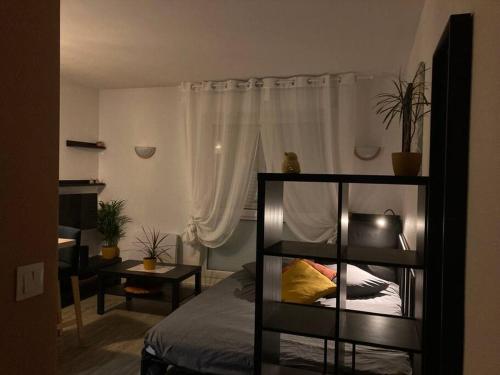 布雷斯特Cozy'Nest的一间卧室配有一张床、一张桌子和一个窗户。