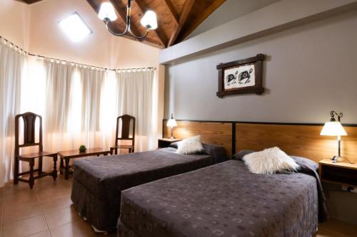 埃尔卡拉法特冰川德拉巴塔哥尼亚酒店的酒店客房,配有两张床和两把椅子