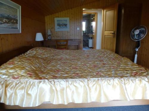 AmsoldingenFerienwohnung Amsoldingen, Berner Oberland, Thunersee Schweiz mit herrlicher Aussicht auf Stockhorn的一间卧室配有一张大床和风扇