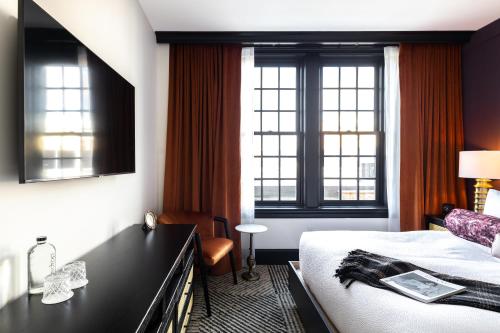 朴茨茅斯Hotel Thaxter的酒店客房设有一张床和两个窗户。