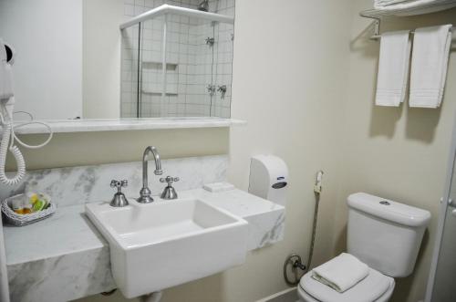 瓜拉雷马Guararema Parque Hotel的白色的浴室设有水槽和卫生间。