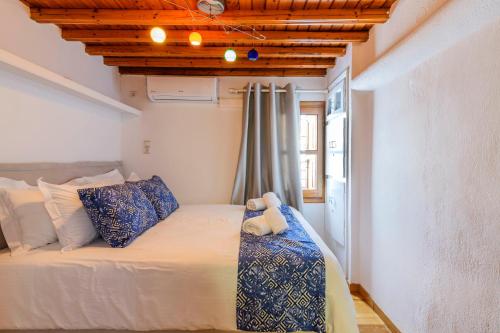 米克诺斯城Dimele的一间卧室配有一张带蓝白色枕头的大床