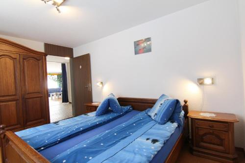 FieschertalCasa Yolanda Familienwohnung Mireille的一间卧室配有一张蓝色的床和木架