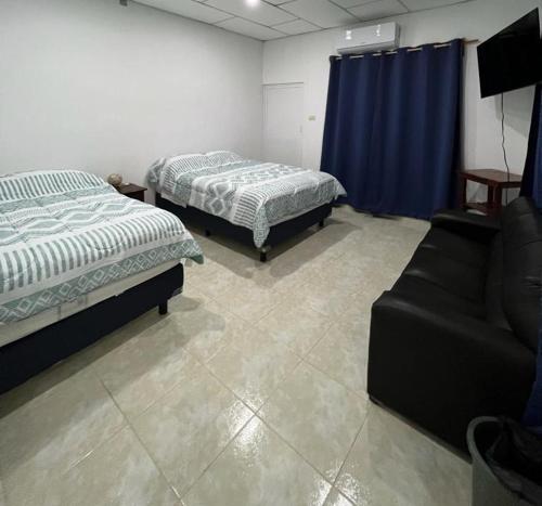 Emiliano ZapataCasa Grace的一间设有两张床和一张沙发的房间