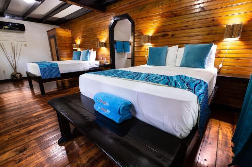 乌蒂拉Mango Inn Resort的一间卧室配有两张床和镜子