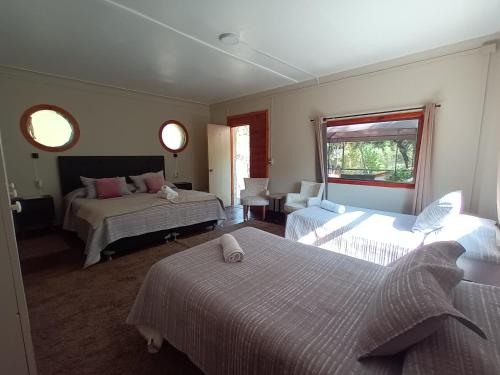 圣阿方索Hostal Los Peñones的酒店客房设有两张床和窗户。
