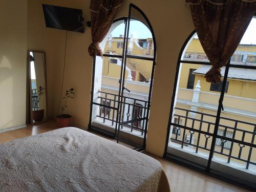 利马Apartamento frente al Palacio Gobierno的卧室设有大窗户,享有阳台的景色