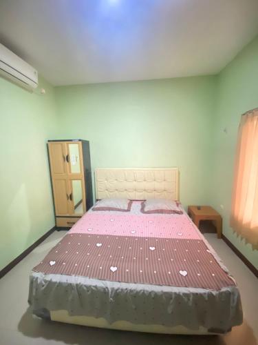 TangkilKarina Guest House Syariah的一间卧室,卧室内配有一张大床