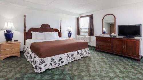 MelvilleBest Stay Inn的一间卧室配有一张大床和一台平面电视