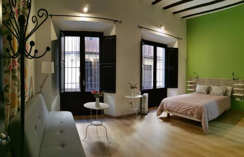 格拉纳达El Granado Hostel的一间卧室设有绿色的墙壁、一张床和一张桌子