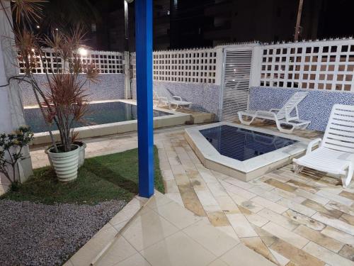 塔曼达雷CASA DA NINA的一个带两把椅子的庭院和一个晚上的游泳池