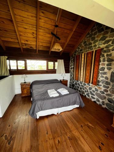 阿苏尔Cabañas Las Tahonas的一间卧室设有一张床和石墙