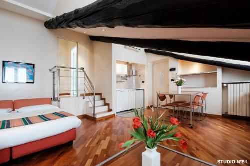 都灵Residence Sacchi Aparthotel的一间卧室配有一张床铺和一张桌子,还设有一间厨房