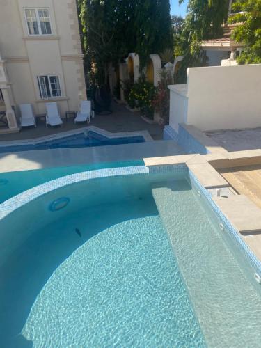 Lance aux ÉpinesMandela Court Suites Grenada的房子前面的蓝色游泳池