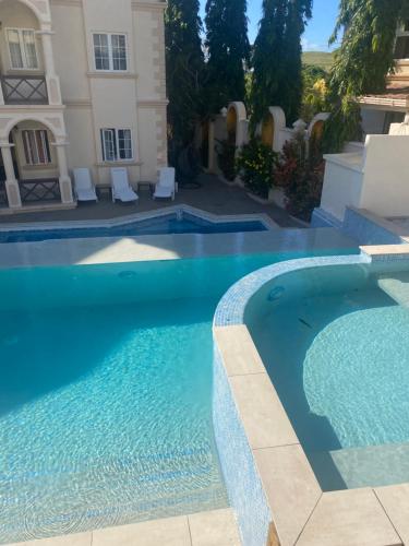 Lance aux ÉpinesMandela Court Suites Grenada的房屋前的游泳池
