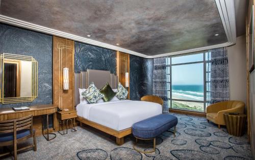 德班Suncoast Hotel & Towers的一间卧室配有一张床、一张书桌和一个窗户。